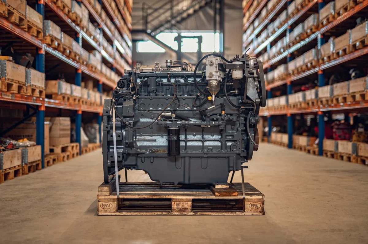 Generalüberholter Sechszylinder-Dieselmotor auf einer Palette im Ersatzteillager mit Regalen