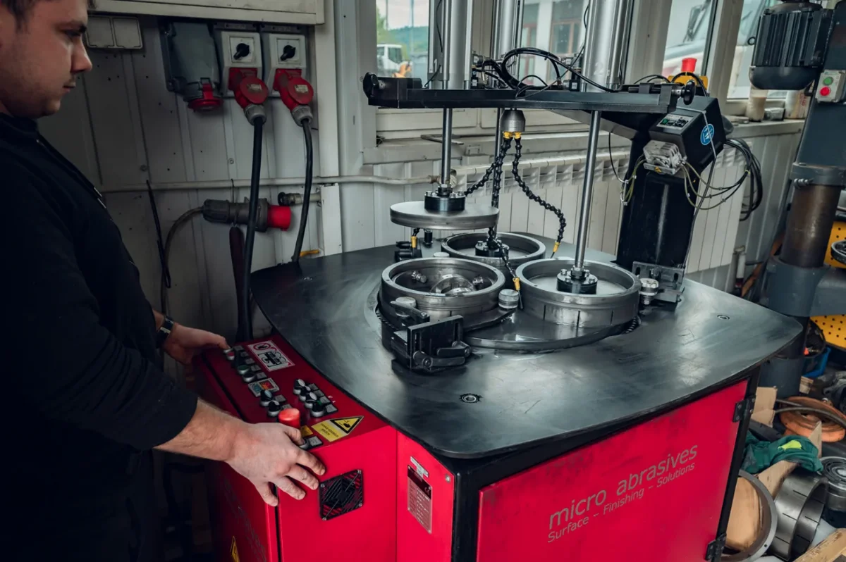 Mitarbeiter bedient eine Läppmaschine zur Bearbeitung von Planflächen an Hydraulikteilen