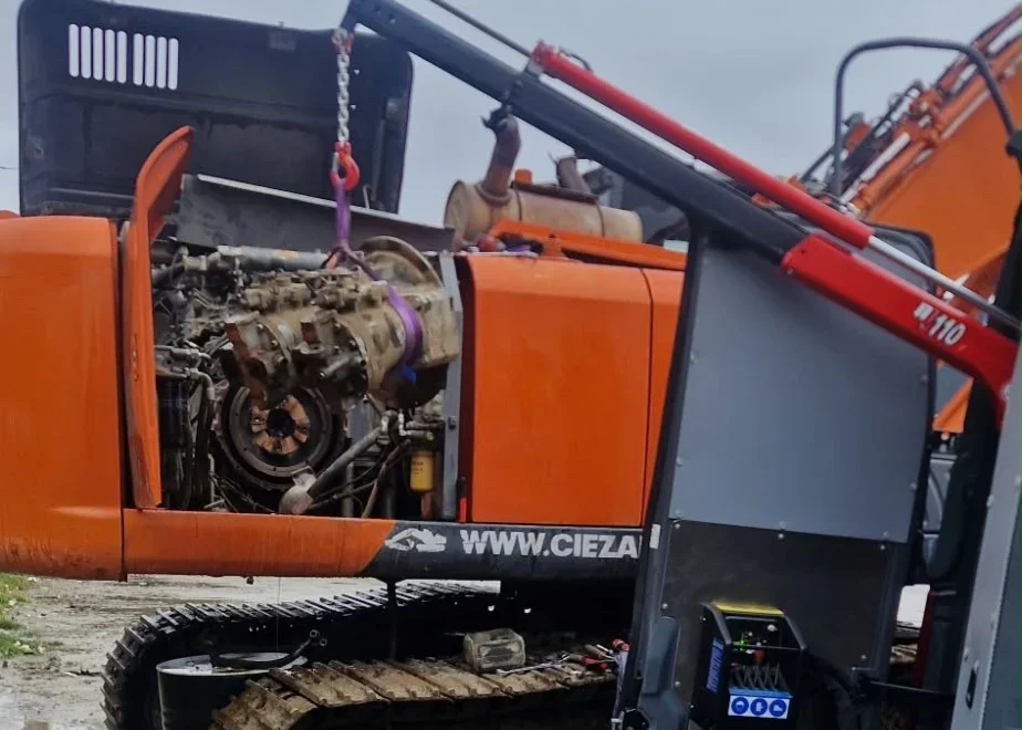 Hydraulikpumpe eines Hitachi ZX350LC-3 wird an der Schlinge des Krans aus dem Servicewagen aus dem Maschinenraum gehoben